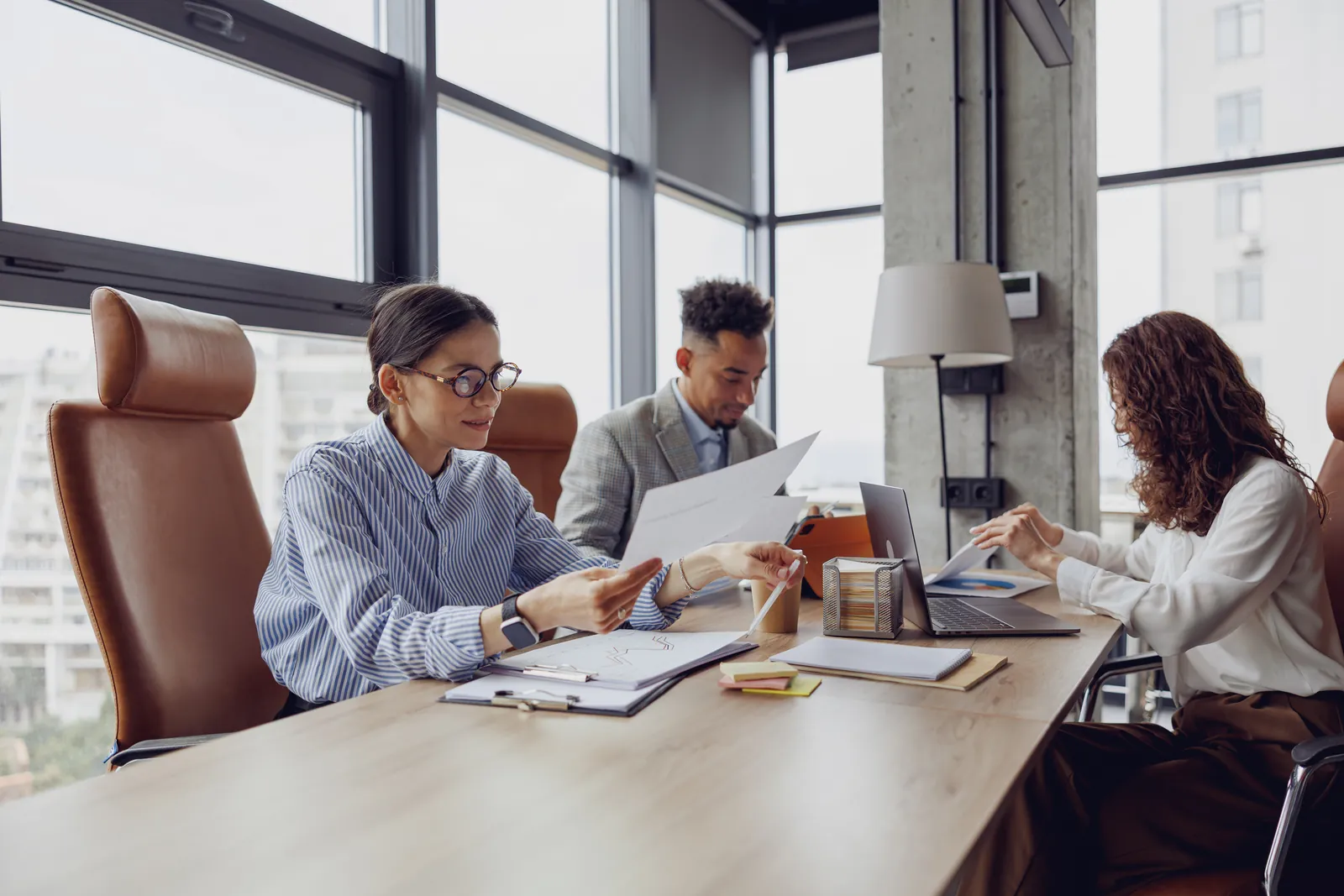 Attorney and paralegals reviewing a medical chronology together at a conference table before drafting a demand