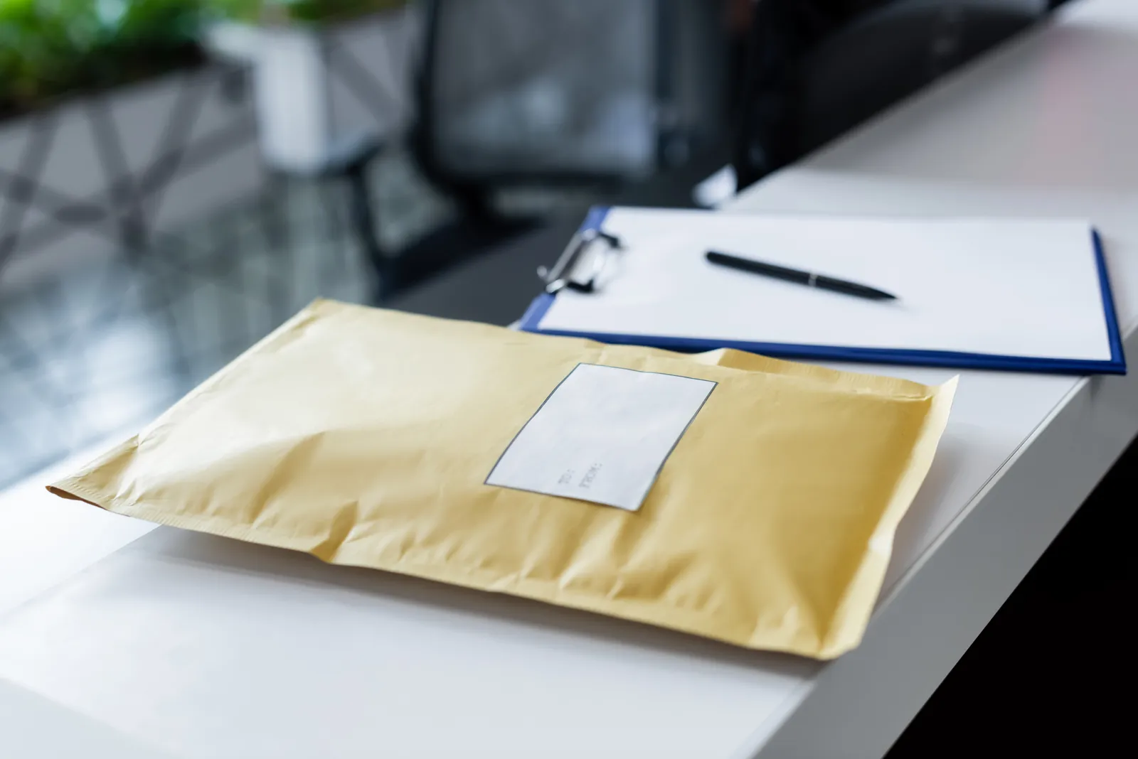 Padded envelope and documents on a white desk, representing a time-limited demand sent by mail