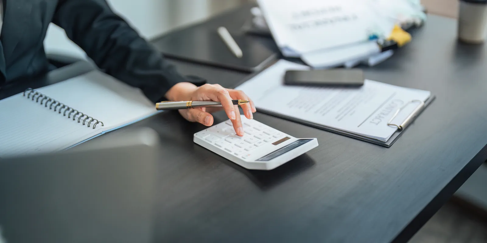 Paralegal totaling special damages on a calculator next to the medical bills for a settlement demand letter
