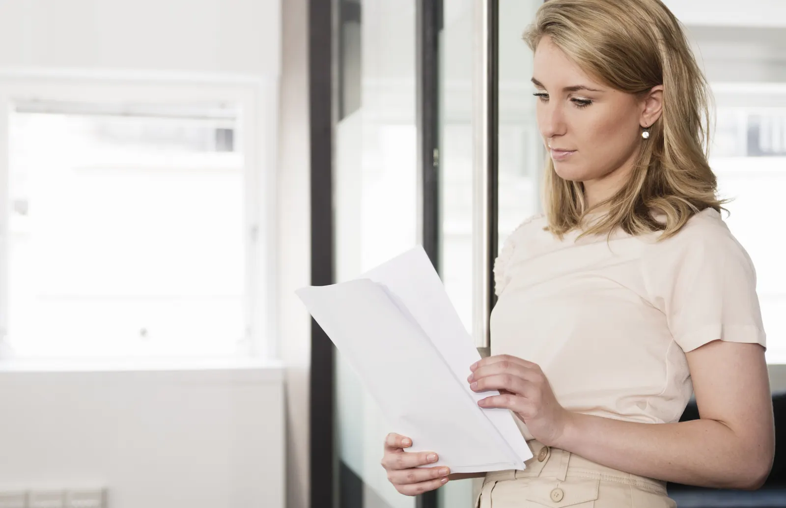 Paralegal reading through printed medical records while building a medical record chronology for a personal injury case