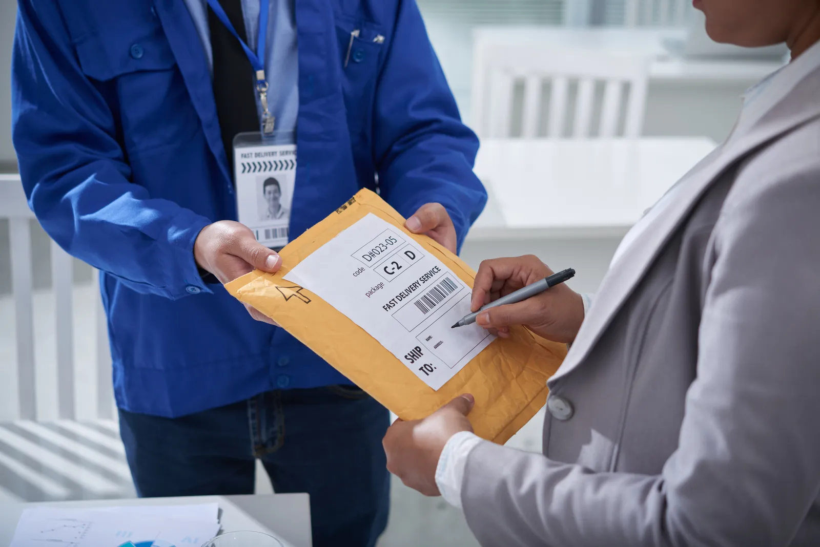 Office worker signing for a delivered envelope of medical records at a law firm