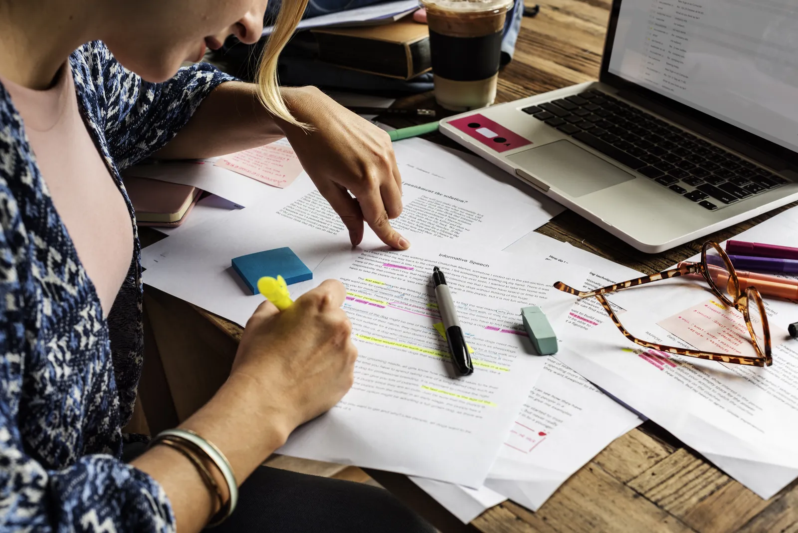Reviewer highlighting findings in printed medical records during a medical record review for a law firm