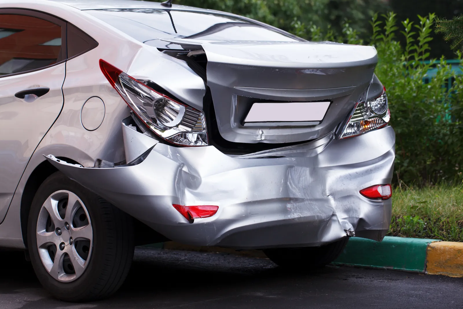 Rear-end collision damage to a silver sedan, the kind of property damage evidence a car accident demand letter should document