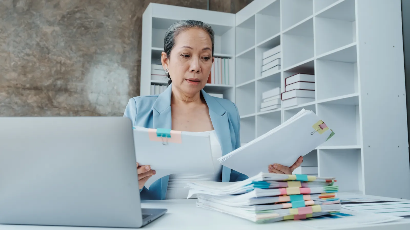 Paralegal organizing tabbed medical records and bills while preparing a car accident demand letter